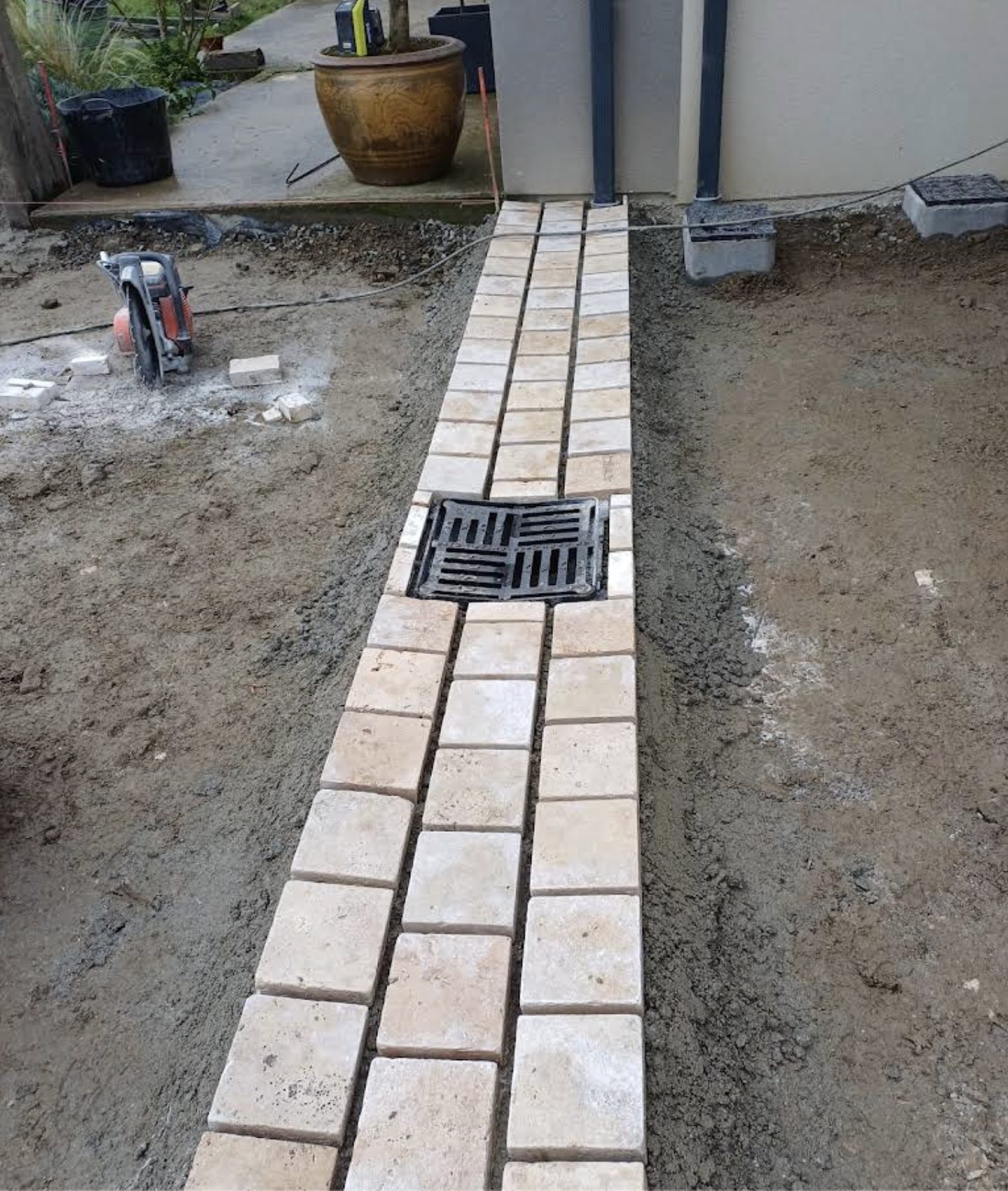Caniveau pavé avec grille d'évacuation — finition soignée d'un chantier de terrassement Delemartp