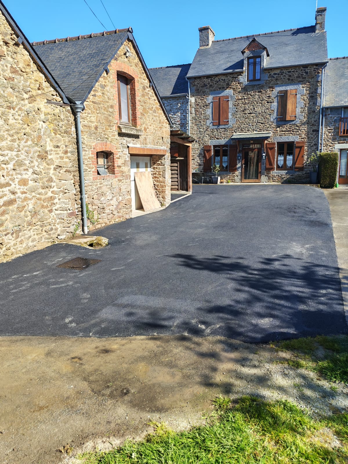 Cour en enrobé devant une maison bretonne en pierres — chantier de terrassement Delemartp en Ille-et-Vilaine